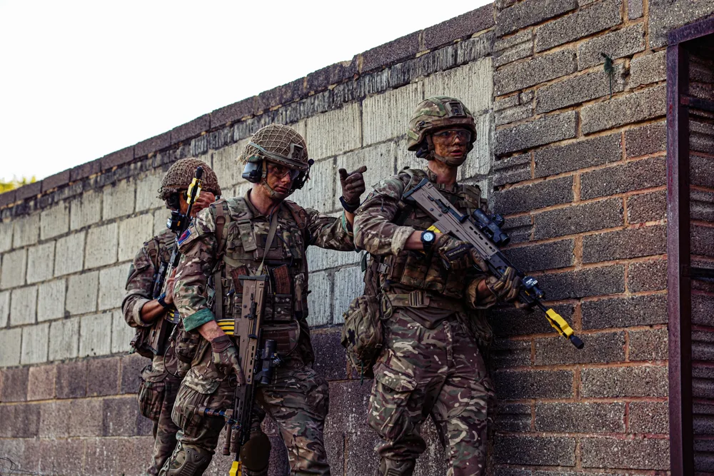 Soldiers beside a brick wall