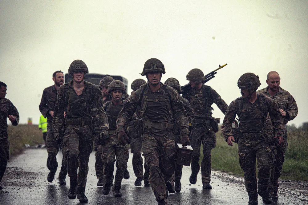 Soldiers running together on a wet road