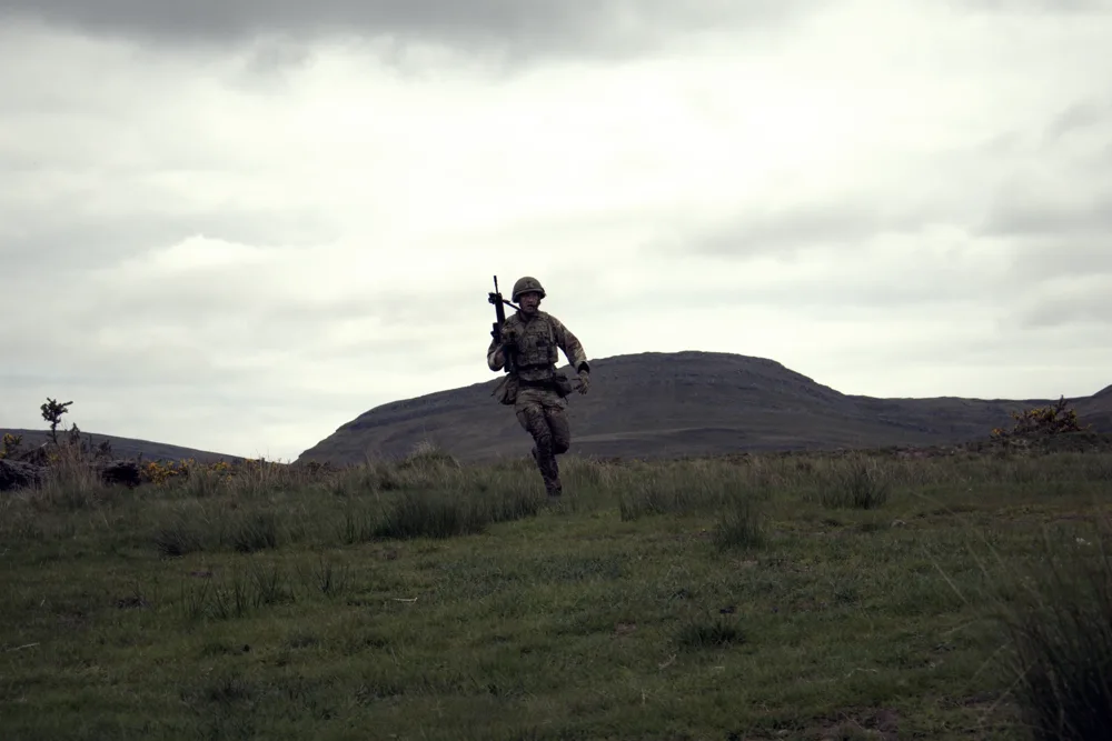 Lone soldier crossing open moorland