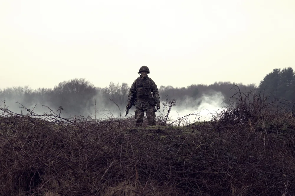 Soldier standing amid smoke on a training exercise