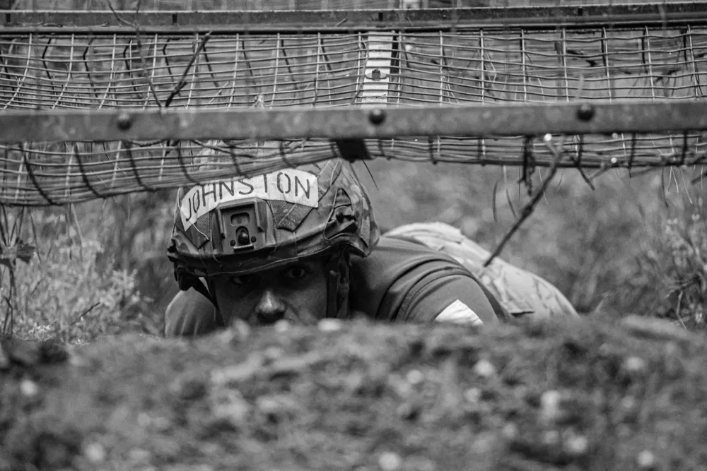 Close-up of a soldier beneath an obstacle