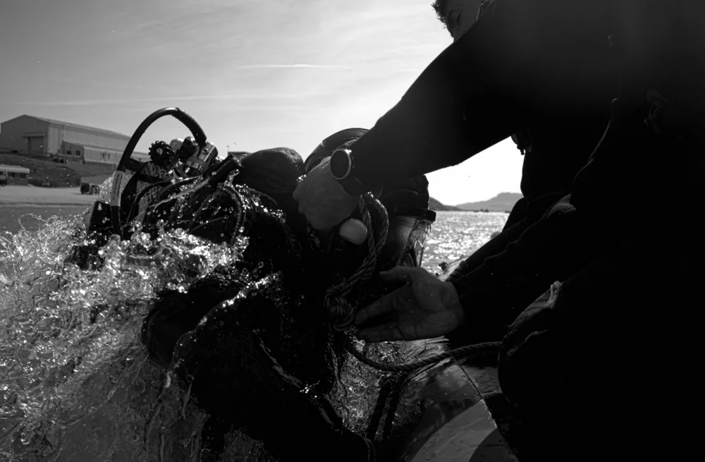 Diver in the water beside a support boat